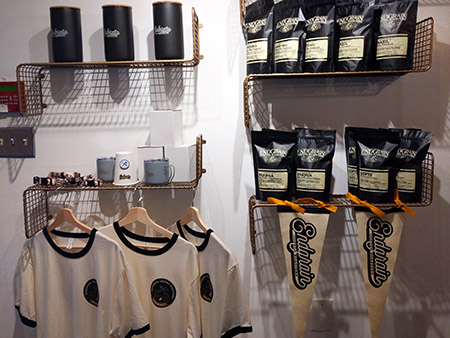 Photo of shirt, cans for coffee, coffee bags, and other merchandise